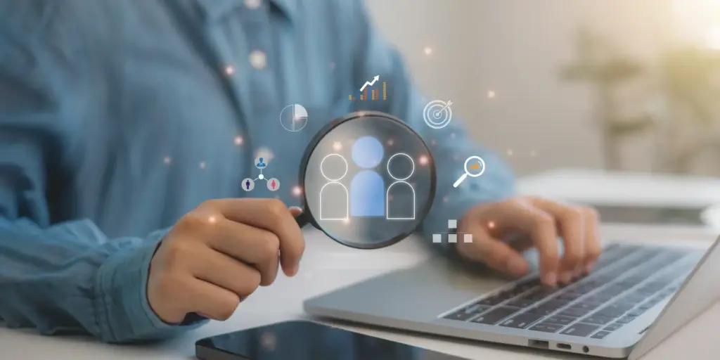 Persona utilizando un portátil mientras analiza datos y clientes con iconos digitales, representando la gestión empresarial y CRM en Odoo