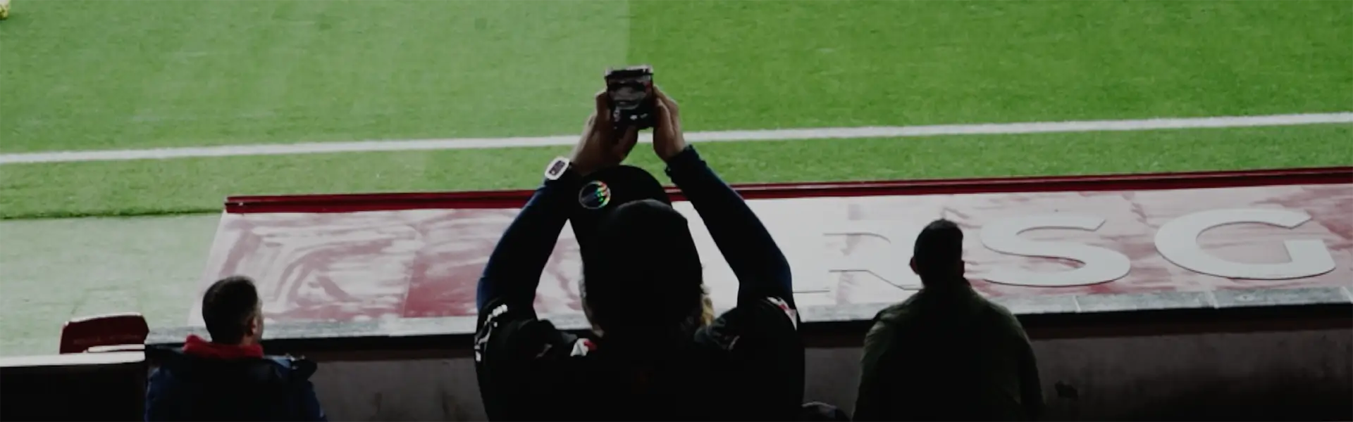 Aficionado del Real Sporting de Gijón fotografiando el partido desde la grada con su móvil en El Molinón